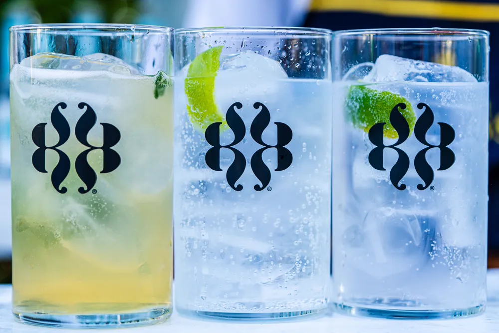 Three identical branded glasses lined up in a row, each carrying the same logo.
