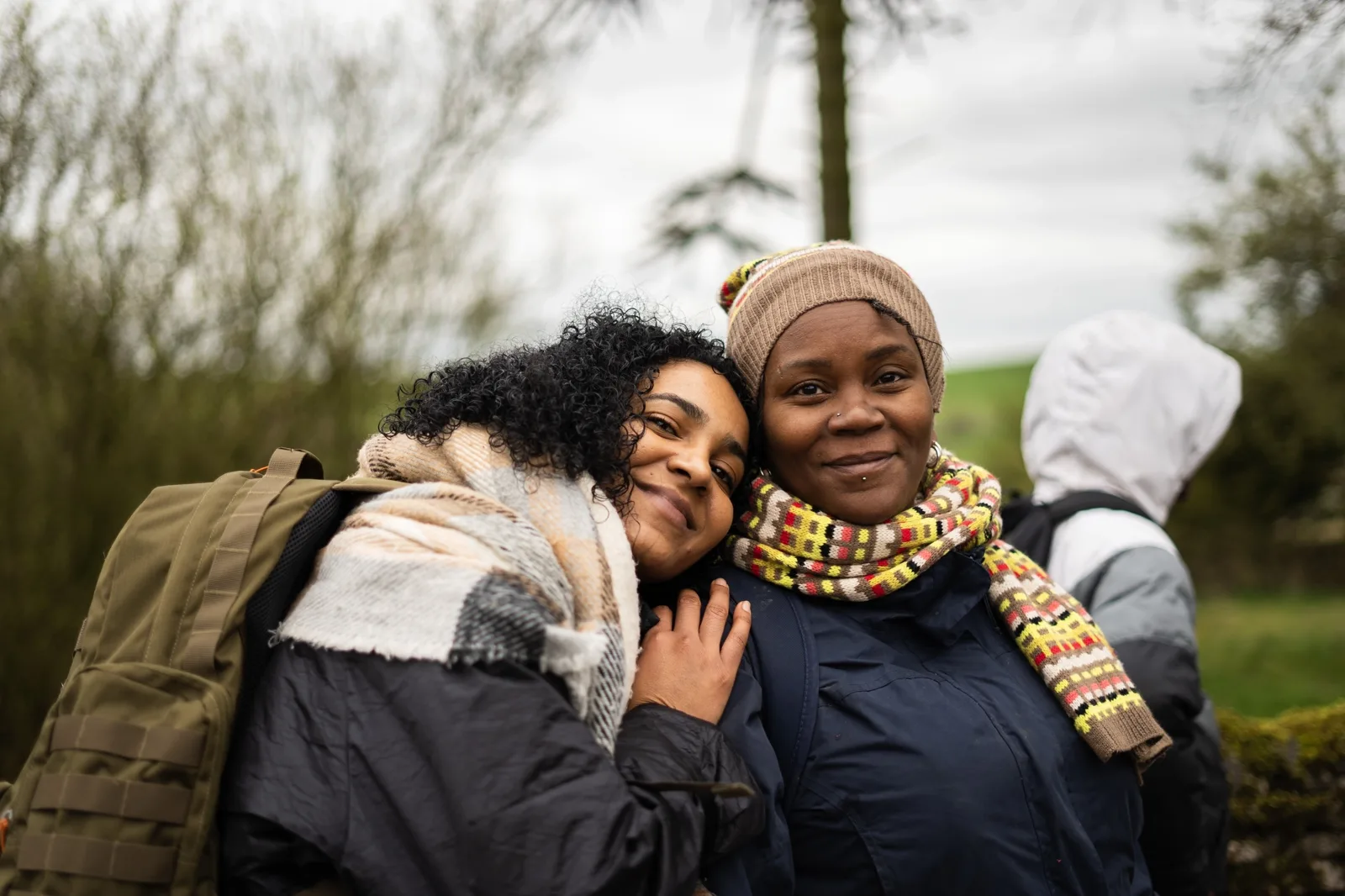 Two members of the 9 Wanders community embracing on a hike