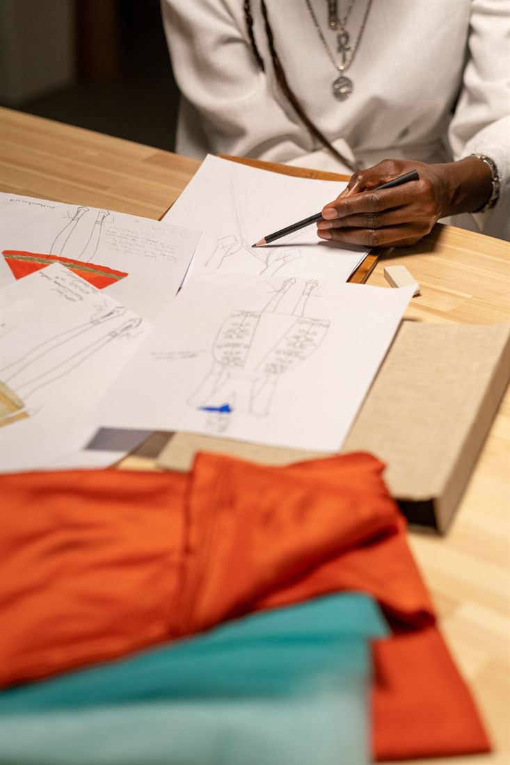 A designer sketching brand concepts beside fabric swatches